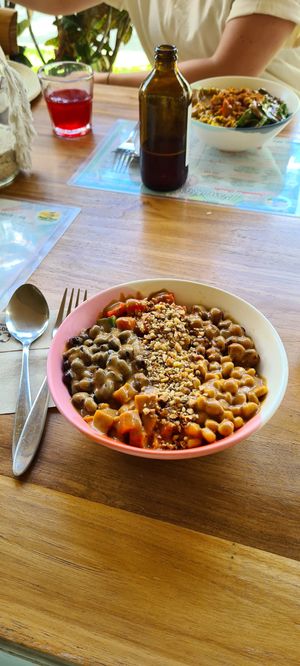 Bowl with black beans, chickpeas, sweet potato, tomatos, corn, quinoa. Toppen with peanut sauce at One Happy Bowl in Noord