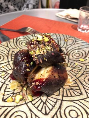 Warm dessert with banana, chocolate sauce, red berries, dried exotic fruits and pistachio topping at Purpura Project in Alicante