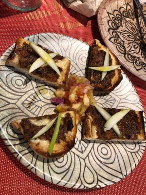 Toasts with vegan morcilla and apple with fruit salad at Purpura Project in Alicante