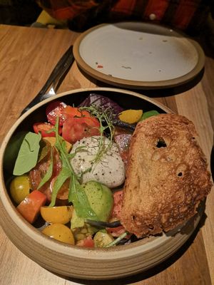 Burrata de cajú con tomatitos orgánicos y hojas verdes at SACRO in Buenos Aires