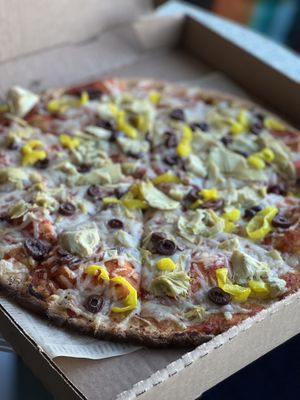 Gluten-free and vegan cauliflower crust with vegan cheese, banana peppers, artichokes, and olives   at Mooses Tooth in Anchorage
