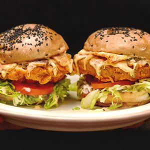 Crispy vegan chicken patties in a fresh brioche bun, with shredded iceberg salad, sliced tomato and gerkins, sautéed onion, dried pineapple, mayo mustard and chili tzatziki sauce. at Manggis in Canggu in Canggu