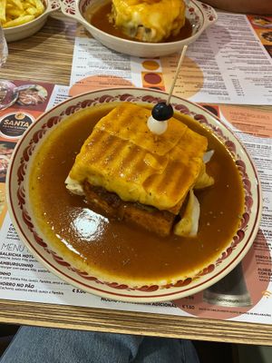 Francesinha 100% vegan (pão de forma, cogumelos, tomate, cebola, bifinhos de seitan, queijo vegetal, chouriço de soja, courgette, salsicha vegana e molho 100% vegano) - 13,90€ at Santa Francesinha in Porto