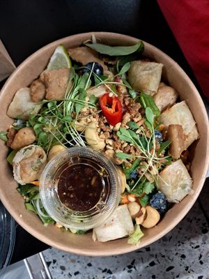 Bowl with spring rolls, vegan chicken and rice noodles at Yummy Bowl in Brussels