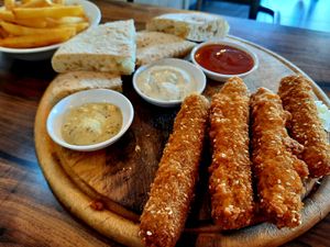 Breaded hot dogs, served with pita, sauces, and fries at Hummus Bar in Haifa