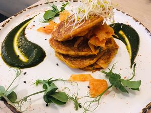 Kimchi Pancakes with daikon pickle salad, dehydrated black olive salt, nasturtium leaf + jang sauce at Stem & Glory in London