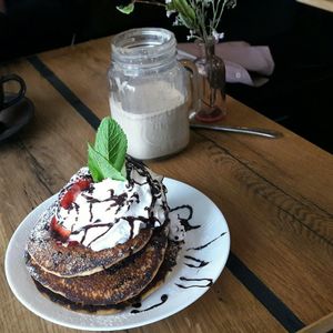 Pancakes with banana, chocolate sauce, whipped cream and strawberries at Veg room in Berlin