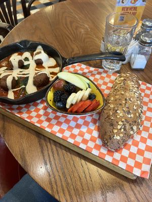 Plant-based (vegan) shakshuka with side of fruit and multigrain bread.   at Cafe Landwer - University Ave in Toronto