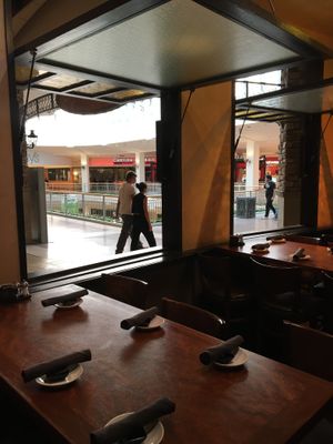 Tables by windows that open to the mall at CRAVE in Bloomington