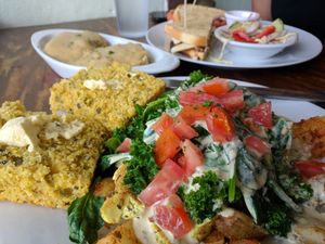 Widower potatoes with tofu, cornbread, and a half order of biscuits and gravy. Happy Waitress sandwich in background. at Wildflower Cafe and Bakery in Arcata