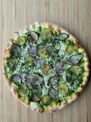 pizza ZIEMNIAK - pesto z jarmuzu, weganska mozzarella,pieczone ziemniaki z majerankiem, topinambur,czerwona cebula at Szybka Pizza in Poznan