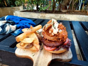 Burger from black beans, walnut with fried onion rings at Coco Calala in Leon