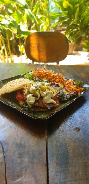 Burger with soy patty, rice paper bacon and ranch dressing, side salad at Coco Calala in Leon
