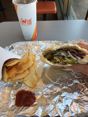 Vegan pita sandwich with falafel, hummus, chopped salad, purple cabbage salad, sumac onions, pickles, tahini sauce & harissa sauce. Side of vegan Naf fries. Lunchtime awesomeness.  at Naf Naf Grill in Eagan