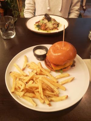 Vegan burger in front and vegan octopus dish in the back  at Kong - Food Made With Compassion in Lisbon