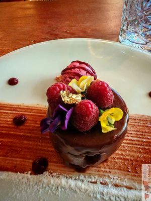 A chocolate cake with red fruit ice cream, beautifully presented! at Kong - Food Made With Compassion in Lisbon