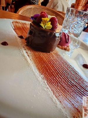 A chocolate cake with red fruit ice cream, beautifully presented! at Kong - Food Made With Compassion in Lisbon