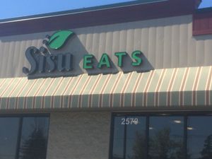 Sign- restaurant in middle of strip mall  at Sisu Eats in Rochester