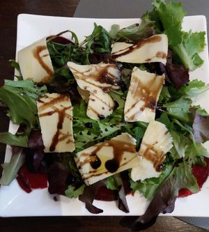 First course: Beet carpaccio topped with greens,  balsamic vinaigrette, and sharp cheese. at Utopia in Nice