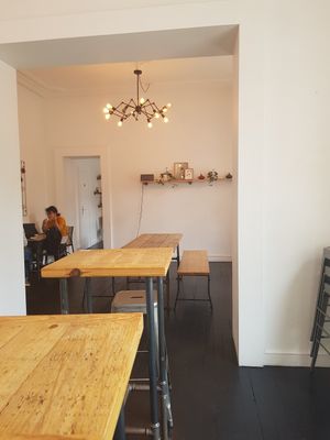 There's another room behind that one with a lot of space, a sofa, and single tables at Bloom in Luxembourg City