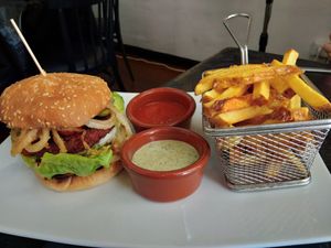 Hamburguesa con patatas y salsas at The Hen's Teeth in Alicante