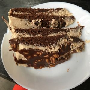 Delicious peanut chocolate cake with creamy layers and a sort of choc peanut brittle topping. SO SO GOOD i want the recipe! at Yoyo Foodworld in Berlin