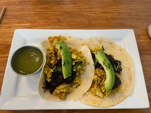 Breakfast Tacos: tofu scramble, black beans, potatoes, avocado, and tomatillo salsa. Can pick between corn and flour tortillas .  at Palm Greens Cafe in Palm Springs