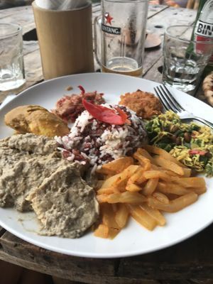 Local delish plate of tempeh curry with rice and 3 other samples of local food.  Vegan if you omit the egg  at Blue Earth Village in Bunutan