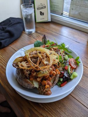 Jacket potato with beans and vegan haggis, topped with crispy onions at Pixie Bakes Cakery and Coffee Shop in Tintwistle
