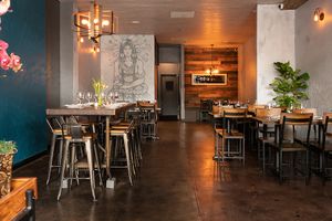 The dining room is a combination of industrial and rustic earthy wood, with a mural that connects the place to shamanism (mystical healers that work with food as medicine) at Modern Shaman in Whittier