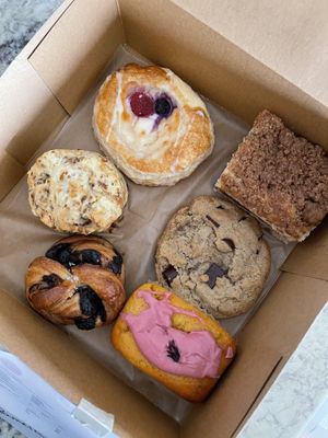 (from left to right, top to bottom row) cheese danish, coffee cake, sausage & cheeze biscuit, chocolate chip cookie, chocolate brioche knot and clementine loaf.  at Hazel & Jade Bakery in San Diego