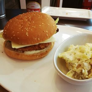 Hamburguesa 'crujiente' con ensalda de patatas y piña at La Factoría Vegana in Leon