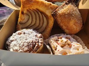 Back: Pear Tart and guava filled pop tart. Front: coffee cake and rosewater pistachio bar at Valhalla Bakery in St Petersburg