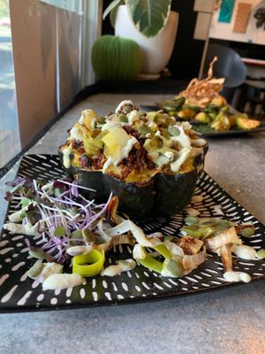 Baked acorn squash filled with quinoa pilaf and pumpkin seeds, topped with cashew crema. at Tender Loving Coffee in Chico