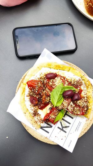 Tiny flatbread (see phone for size reference) at Nola Kitchen in Porto