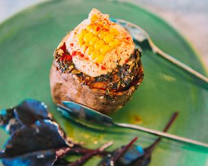 This is a roasted Sweet Potato, topped with a thick tahini yoghurt sauce and corn shards.  at Vegabond - West in Amsterdam