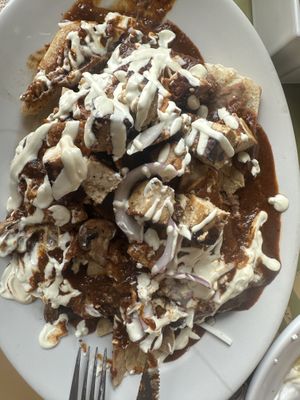 Fully vegan mole chilaquiles with tofu, bread as a base, vegan cheese & sour creamm  at La Cadencia Loncheria in Mexico City