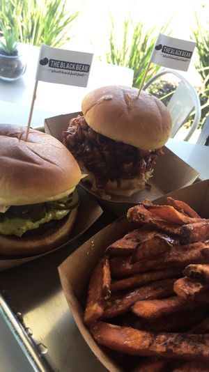 On the left is the nacho daddy burger and on the left is the pulled pork sandwich with sweet potato fries! at The Brave Bean in Fountain Valley