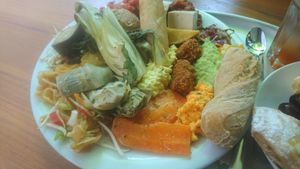 Pakchoi, Chili son carne, Bohnen, linsen Dal, Kartoffeln, harisa, samba, Salat, falafel, Frühlingsrolle, Tofu, Karotten lachs, Edamepaste, Artischocke, Eiersalat, Rüblipaste, Man at Tibits in Basel