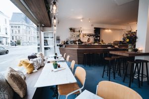 Wood, white, marble, and many plants with a beautiful blue floor at Camion in Antwerpen