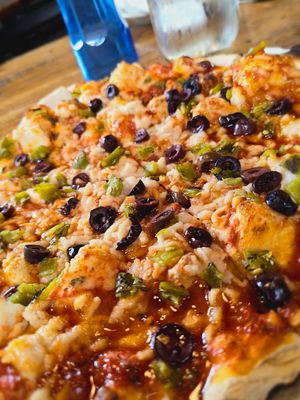 BYO pizza with marinara sauce, vegan mozzarella, kalamata olives, and chopped green chile at Taos Mesa Brewing in Taos