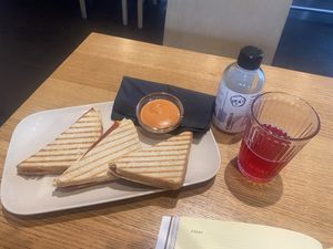 Three ham and cheese toasts and „Isas kombucha“ bottle  at Veganika in Ljubljana