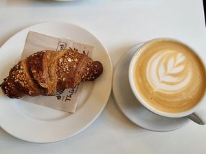 Jam-filled croissant and plant-mylk latte at Flow Specialty Coffee Bar & Bistro in Budapest