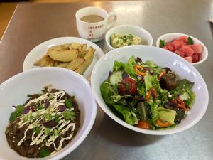 Local greens, fresh fruit, Oven Fries, chickpea salad, chili bowl at One Grub Community in El Paso
