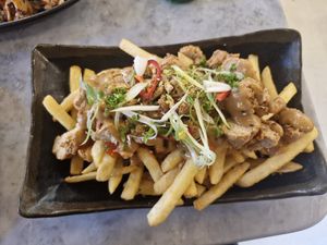 Vegan Chickaan Peanut Butter Fries: Plantbased crispy chickaan, crispy shallots, spring onions, fresh chillies, crushed pistachios, homemade peanut butter & sriracha sauce at Viet Shack in Manchester