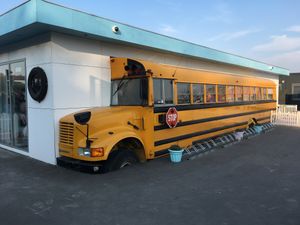 An old american school bus on the side of the building. You can sit inside the bus on the inside.  at Stacy's Diner in Koege