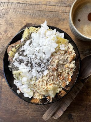 smoothie bowl with banana, cacao, dates, and peanut butter; topped with coconut flakes, pineapple, crushed almonds, and chia seeds   at Flowers & Fire in 