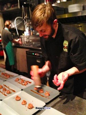 Chef Patterson decorates the plated Rose-Chocolate-Coconut Mousse. at Sutra in Seattle
