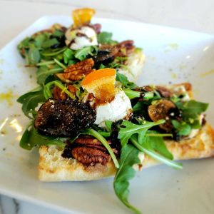 Crostini with Vegan Goat Cheese, Maple Soaked Figs, Candied Walnuts and Arugula at The Vreamery in Paso Robles