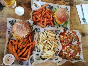 Chicken burger, Beyond Meat burger, Currywurst, french fries and sweet potato fries at Mad Mad Vegan - Chueca in Madrid